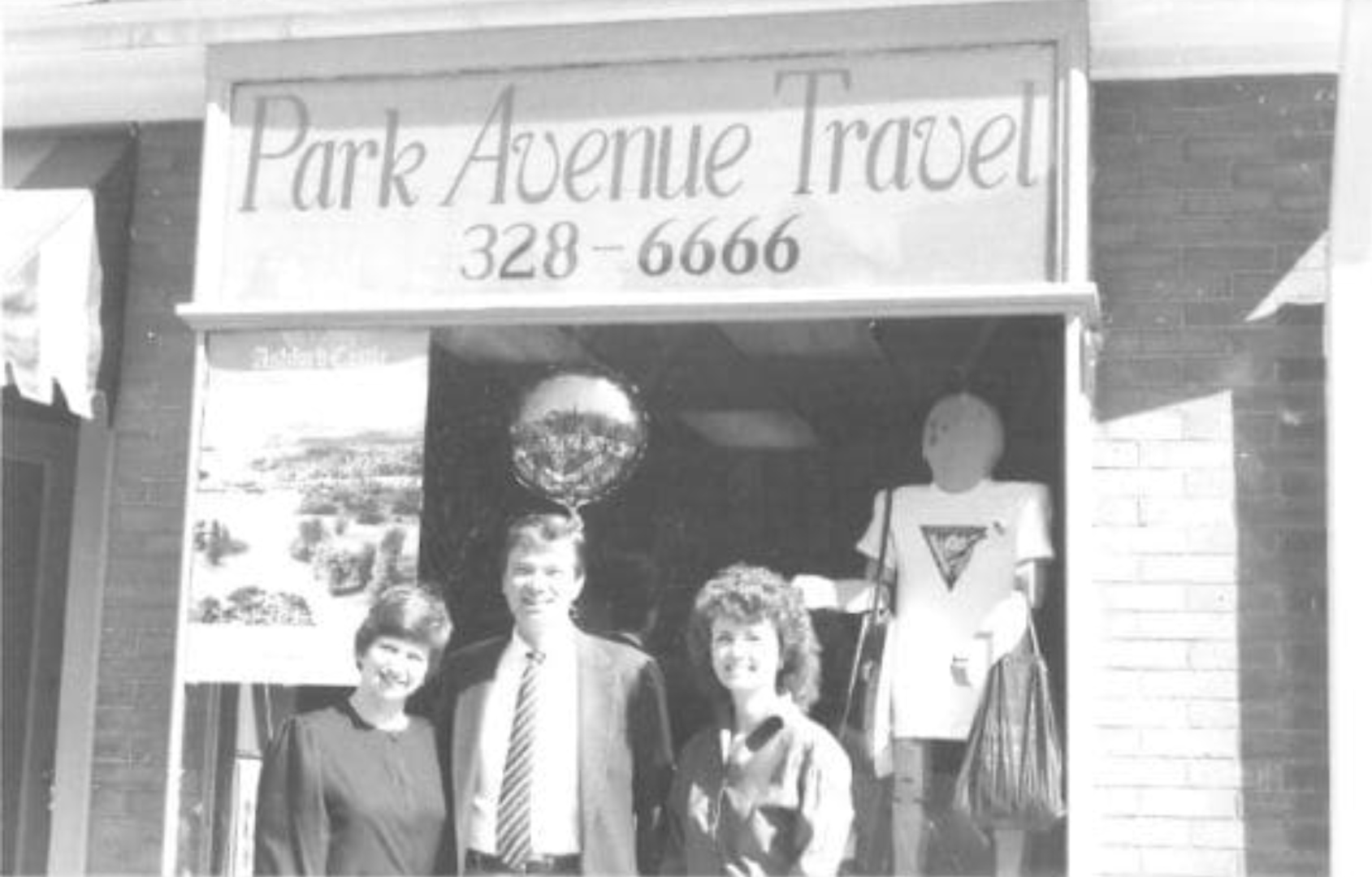 Debbie and Craig Bush in front of Park Avenue Travel storefront